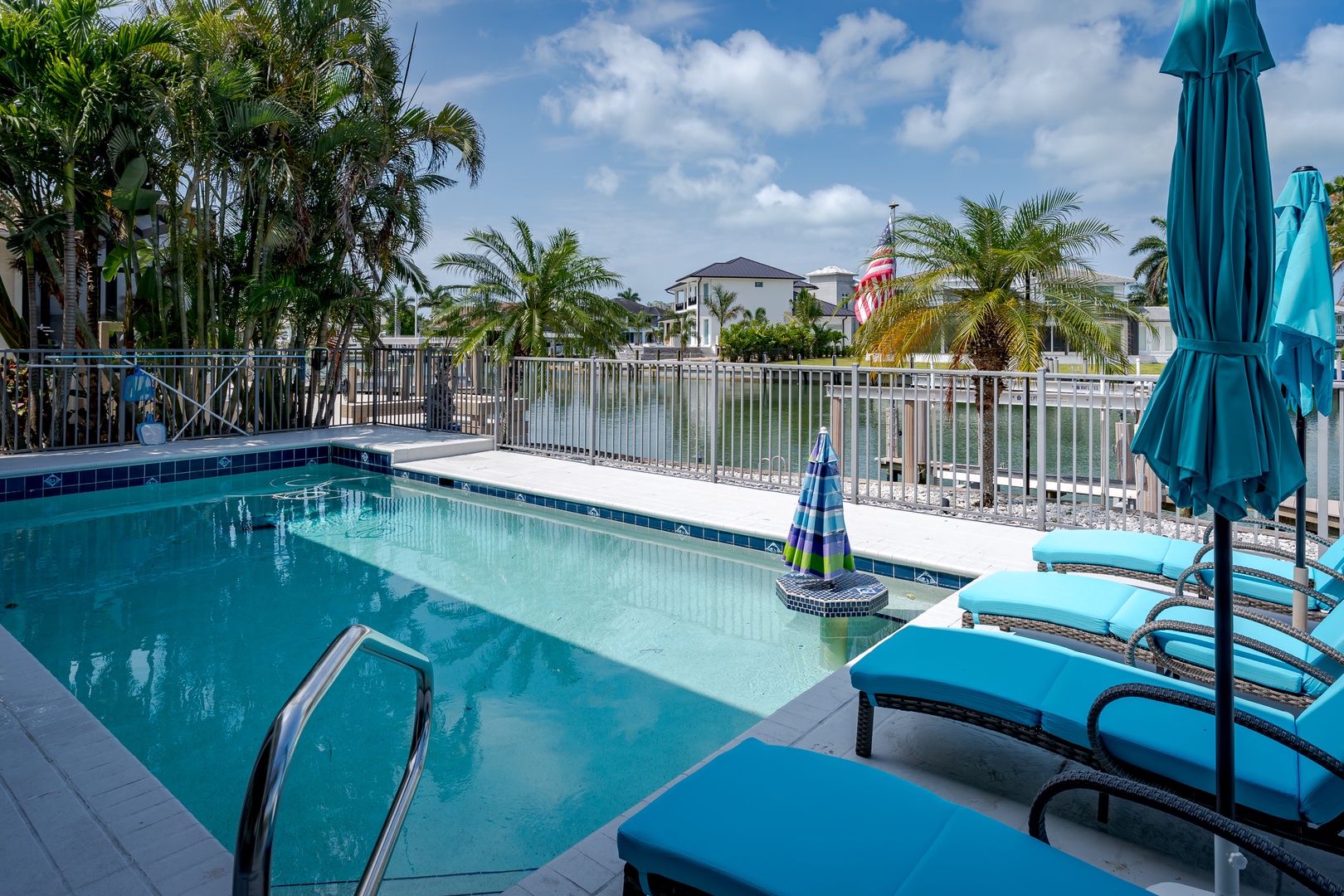 Lounge poolside under swaying palms with serene waterfront views and vibrant turquoise loungers inviting you to soak up the Florida sunshine in complete relaxation.