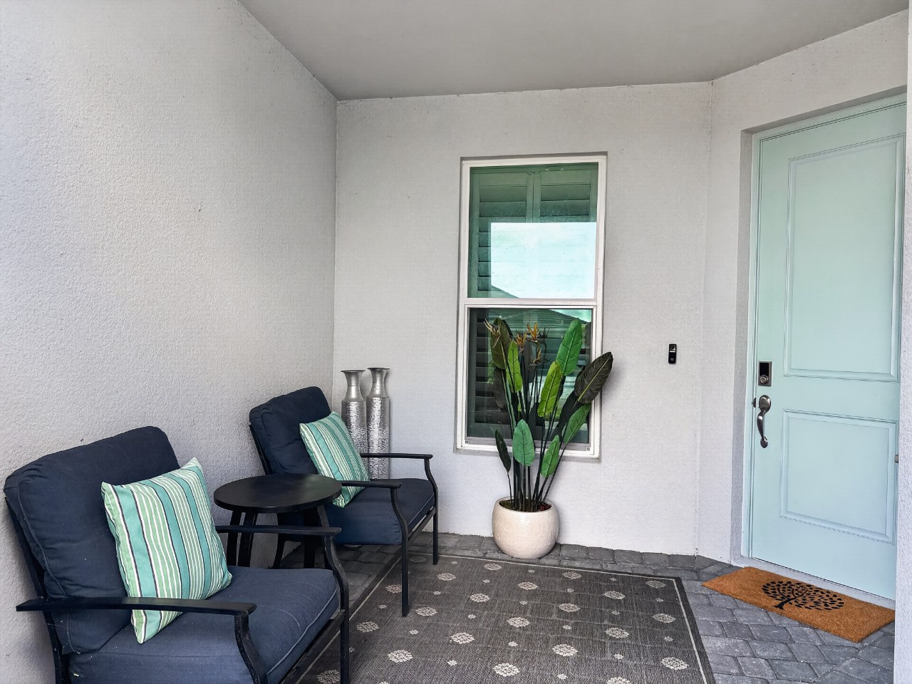 Step through your private entrance into a serene covered patio where coastal-inspired seating invites you to unwind with morning coffee or evening conversation.