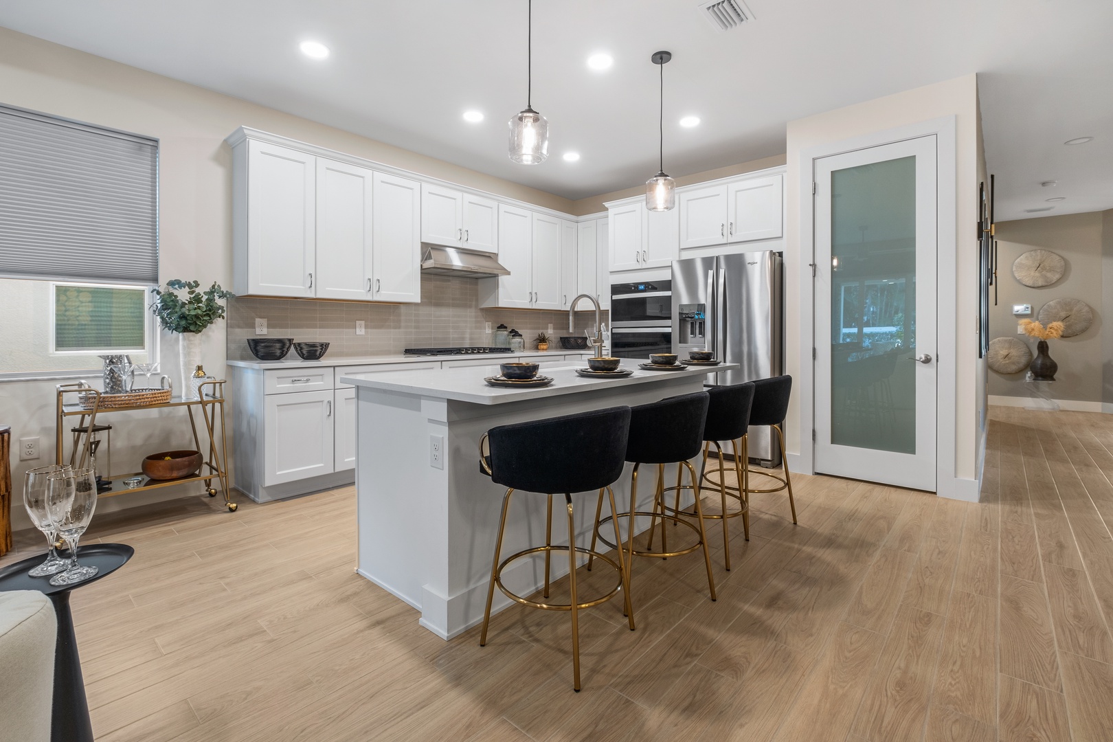 Gather around your spacious kitchen island with sleek white cabinets, granite counters, and modern stainless steel appliances for memorable meals.