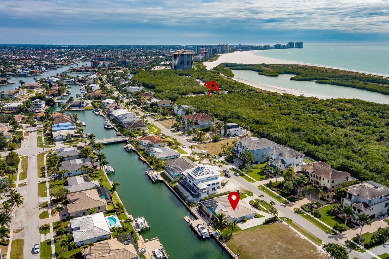 Aerial view showing the coastal neighborhood with waterfront homes, marina access, and pristine beaches nearby.