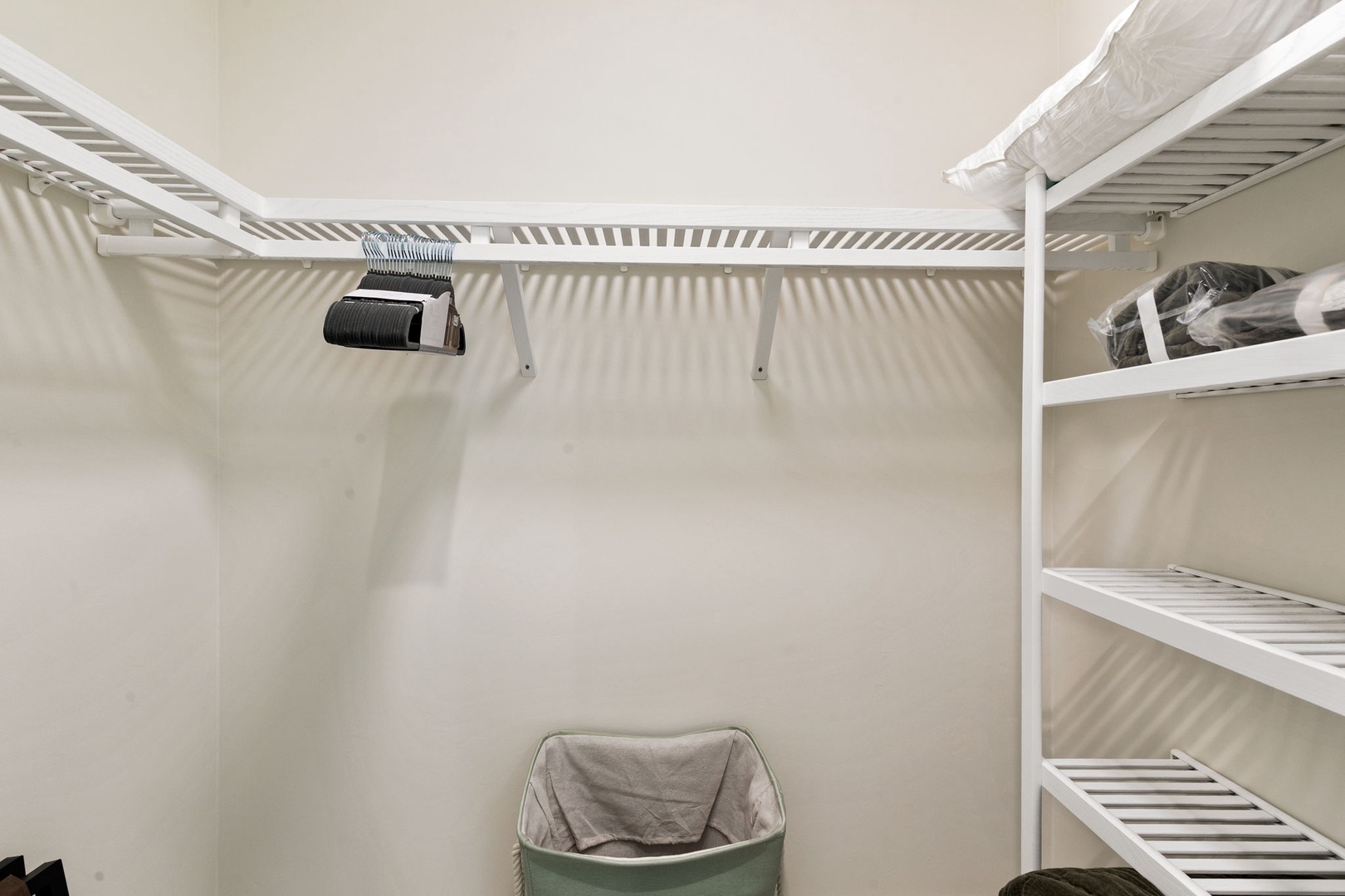 A spacious walk-in closet with organized shelving awaits your wardrobe, complete with a hair dryer and ample storage to keep your vacation essentials neatly arranged.