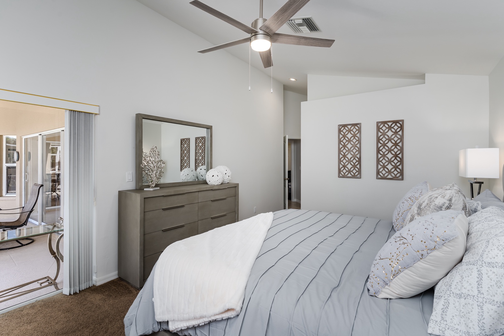 Sink into crisp linens and enjoy the gentle ceiling fan breeze in your serene bedroom sanctuary.