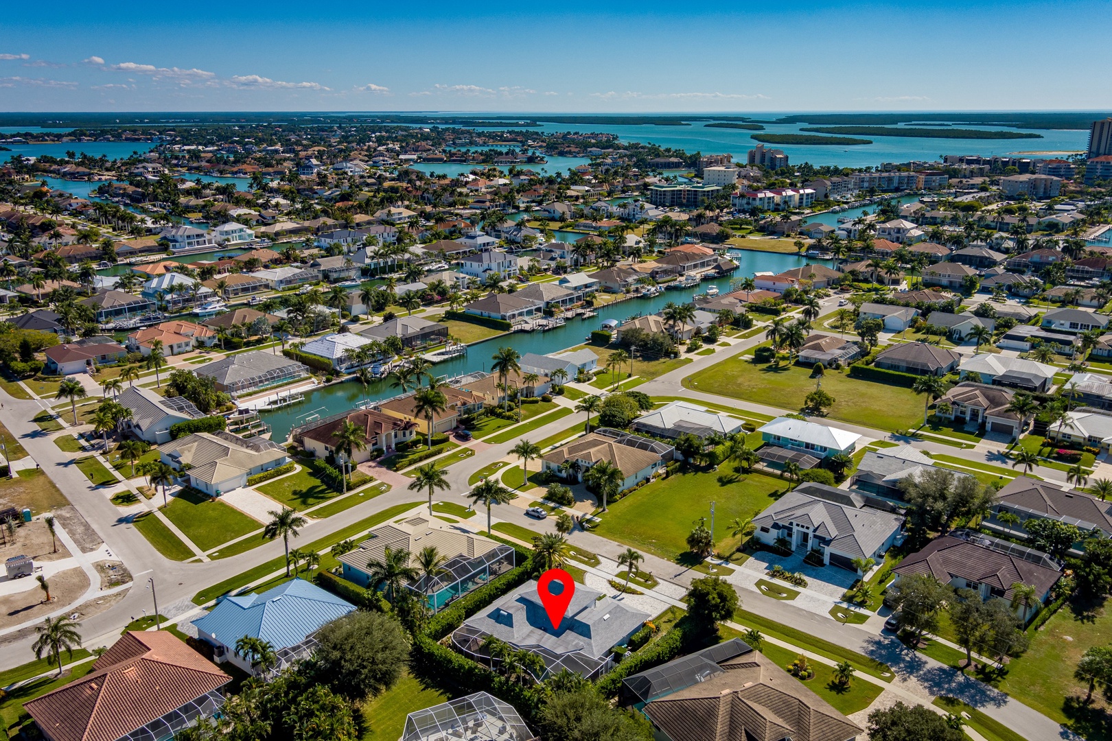 Stunning aerial view of this coastal Florida neighborhood with waterfront canals, palm-lined streets, and direct access to pristine turquoise waters.