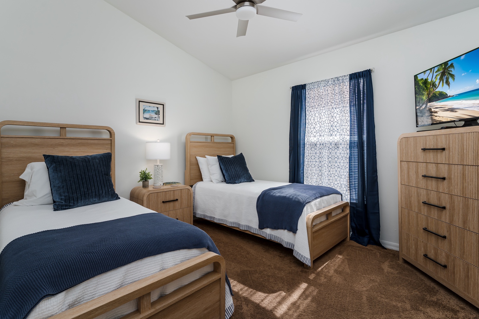 Rest peacefully in your twin bedroom with comfortable beds, coastal artwork, and gentle ceiling fan keeping you cool throughout the night.