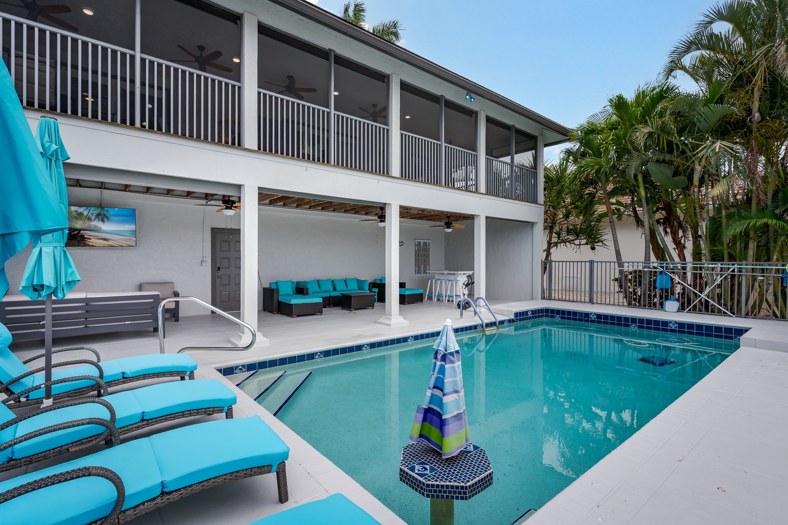 A two-story modern property with a private pool, multiple balconies, and lush tropical palm trees creating a secluded outdoor space for your vacation retreat.