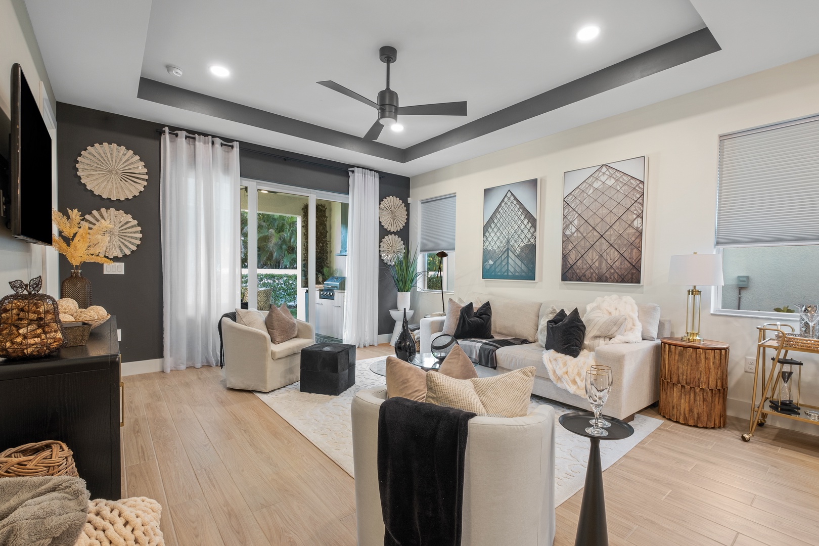 Sink into plush sofas in your sophisticated living space, featuring designer accents and a statement ceiling fan.