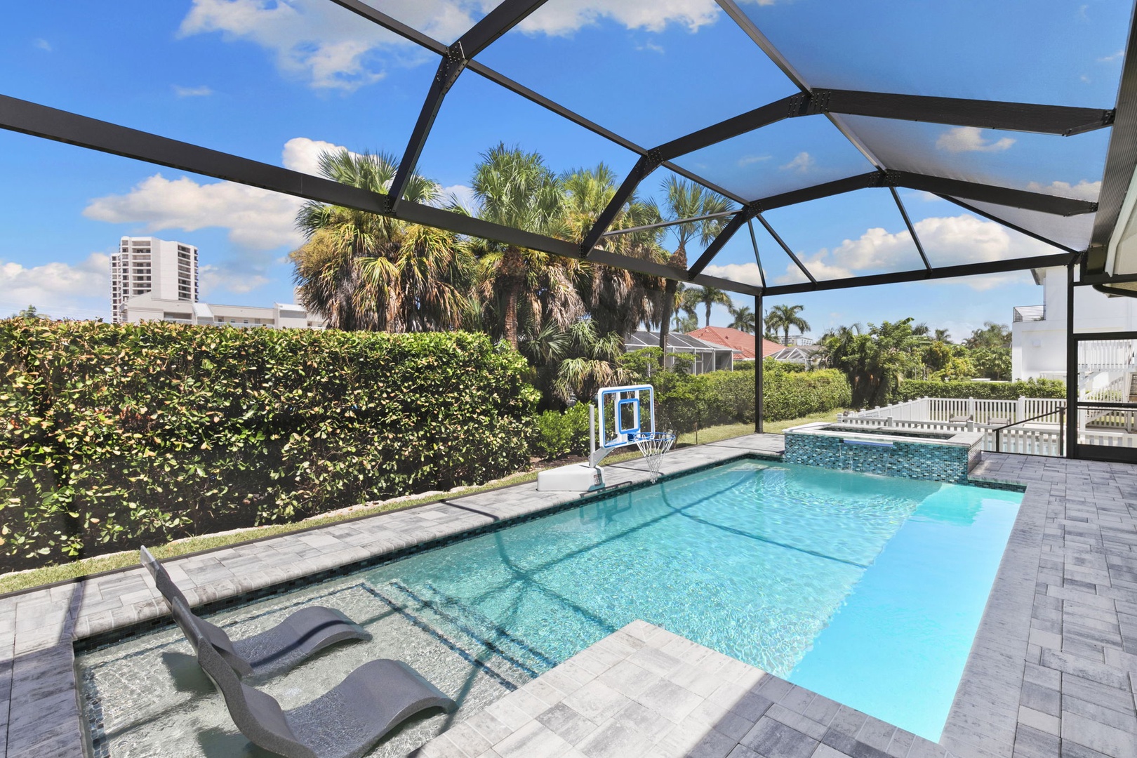 Your private screened pool awaits, surrounded by palm trees and sunshine—perfect for a refreshing dip or lounging poolside with a view of lush greenery.