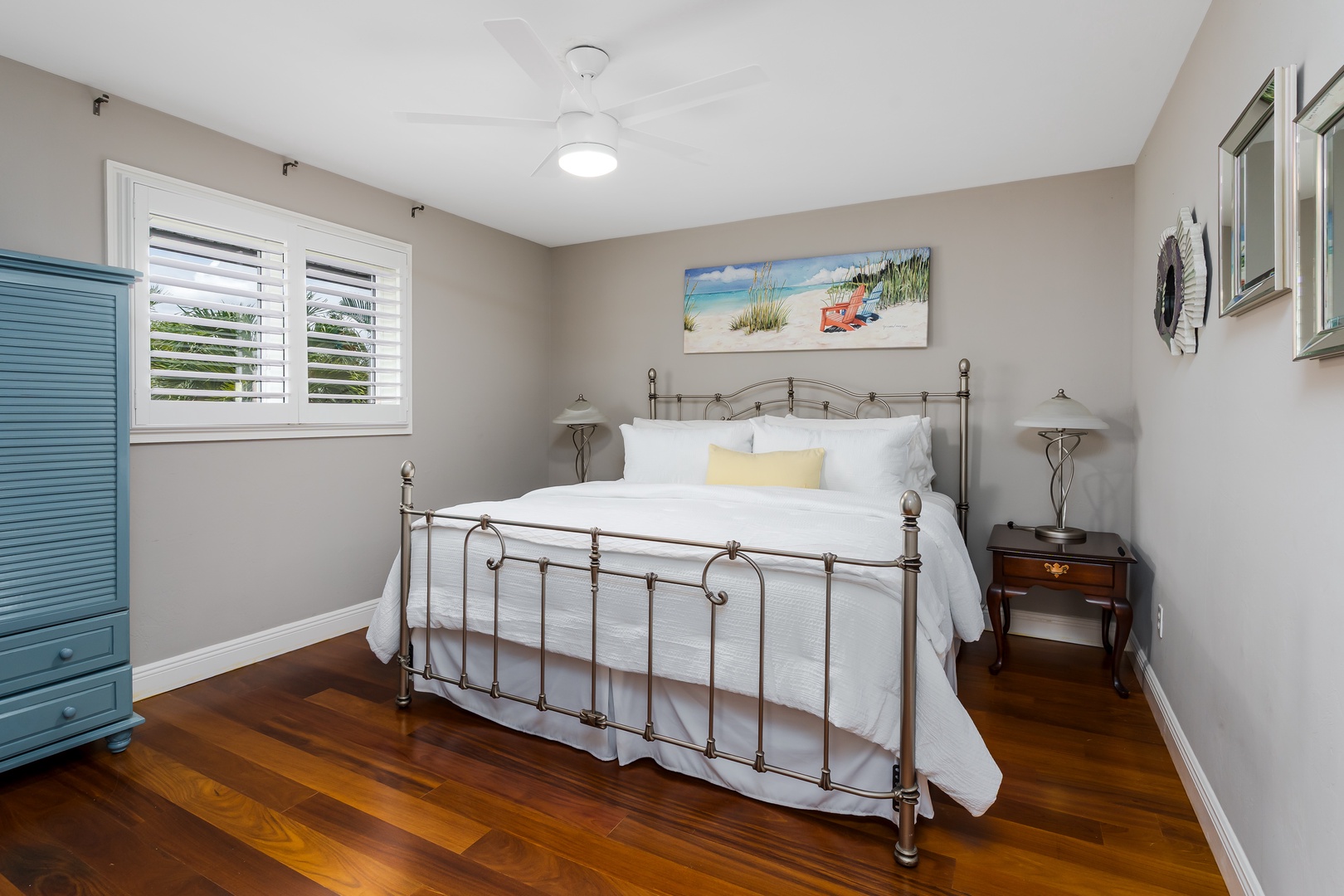 Sink into crisp linens on this inviting bed and let coastal artwork transport you to sandy shores. Rich hardwood floors and soft natural light create your perfect seaside retreat.