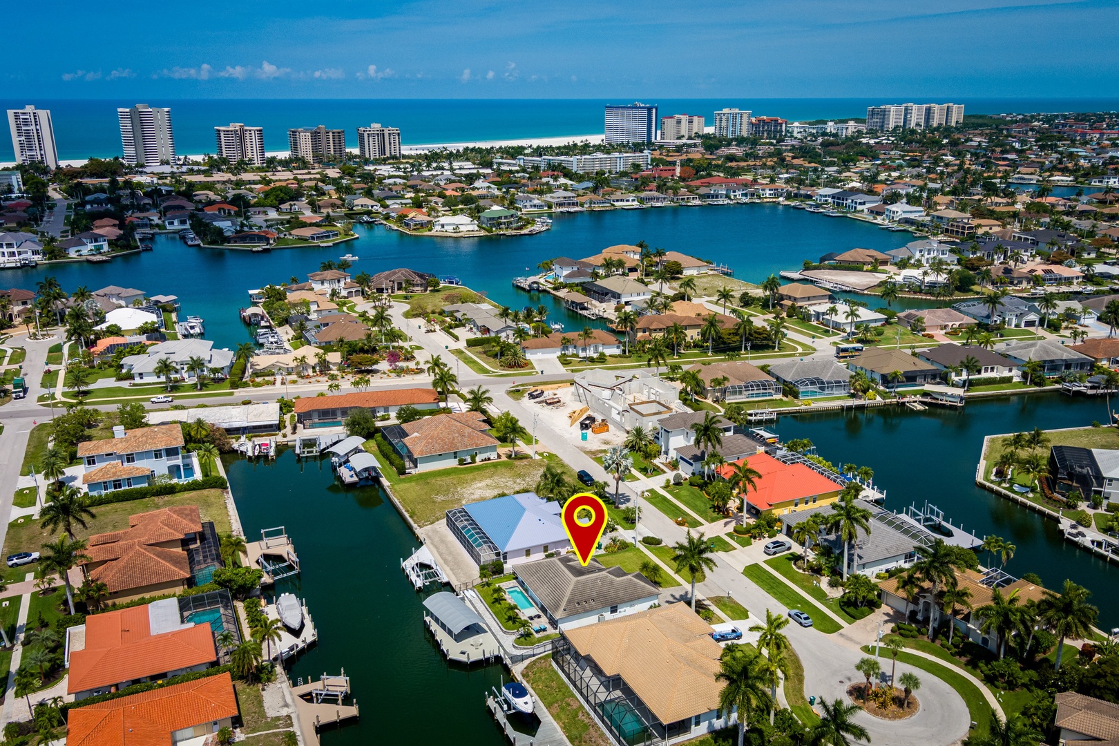 An aerial view showcasing a waterfront vacation property nestled in a picturesque coastal community, with canal-front access and easy reach to pristine beaches and urban amenities.
