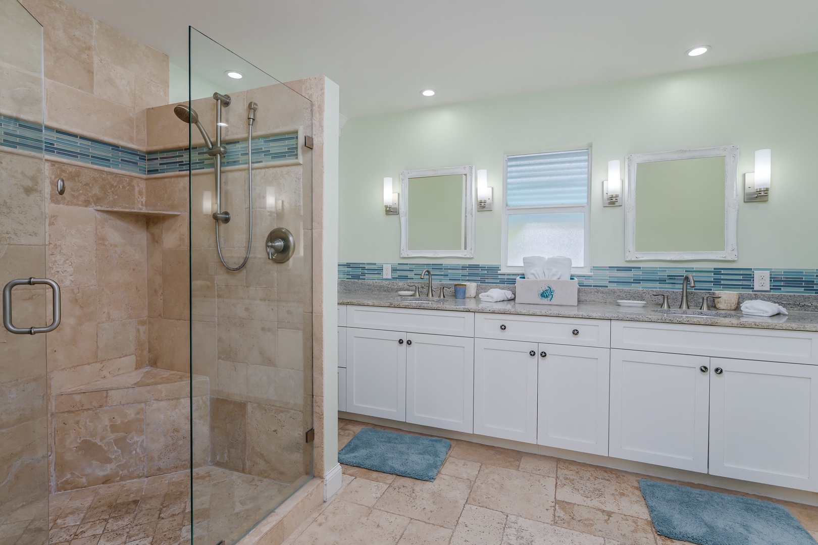 Step into your spa-like sanctuary with dual vanities, luxurious walk-in shower, and soothing coastal tile accents that create the perfect morning retreat.