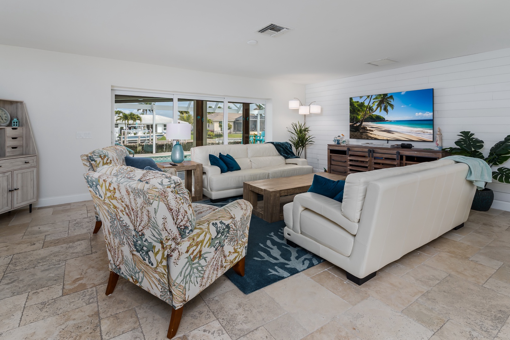 Sink into plush white sofas and watch tropical beach scenes on the large TV while natural light streams through waterfront windows.