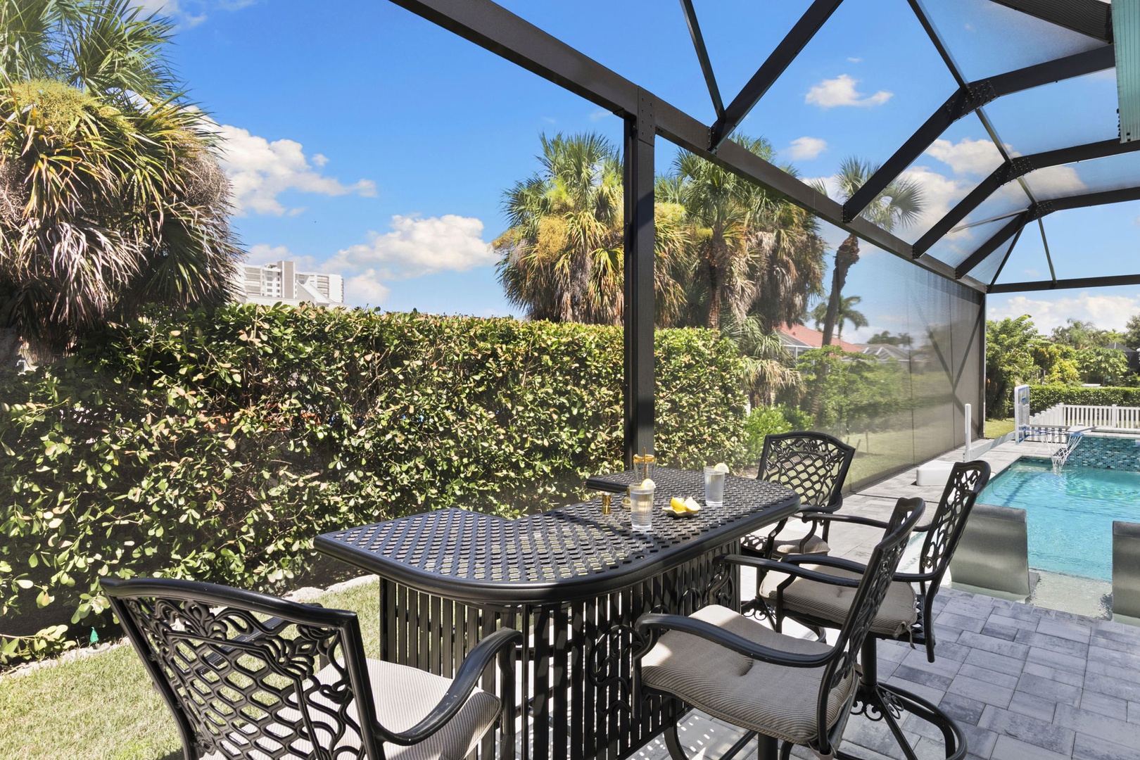 Dine al fresco under your screened lanai, where palm trees sway beyond manicured hedges and your private pool awaits under sunny Florida skies.