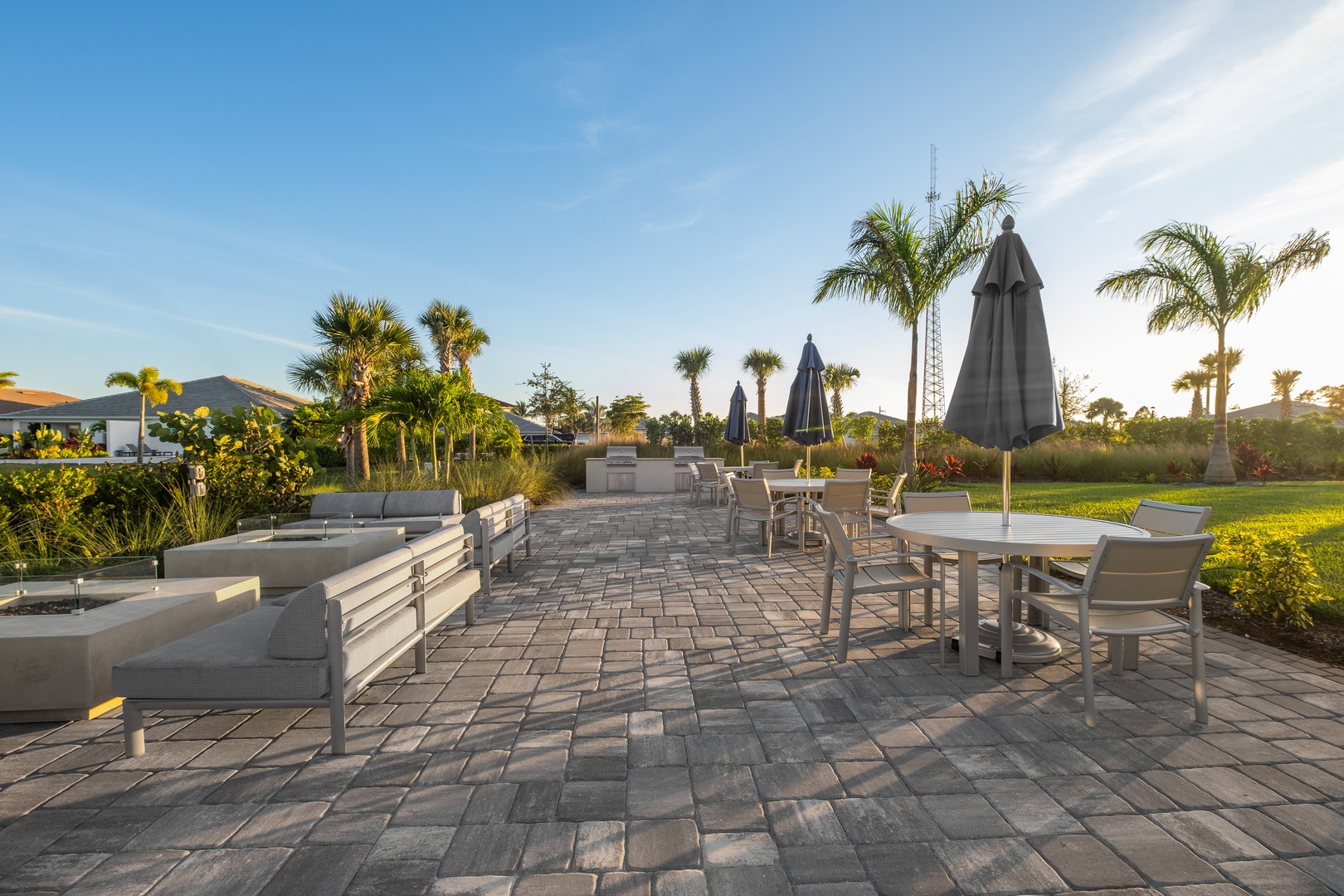 The spacious patio overlooks lush tropical landscaping and open green spaces, creating a serene setting for your morning coffee or evening relaxation under the palm trees.