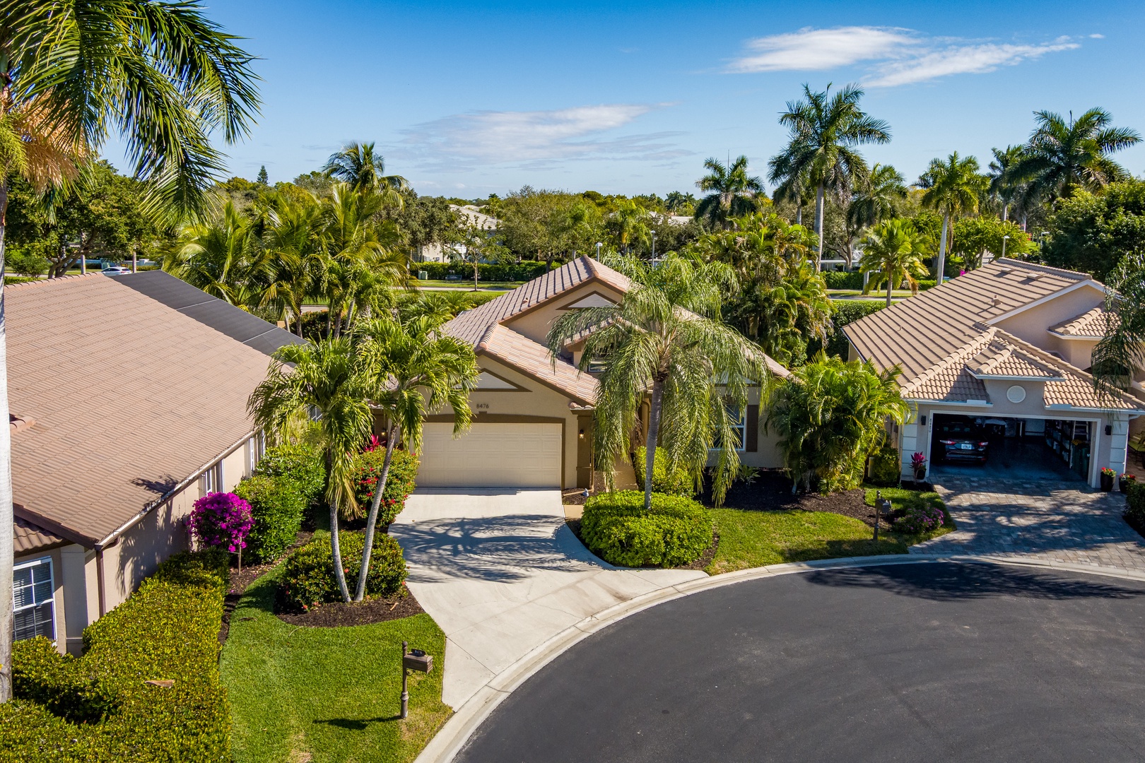 Tropical residential community featuring beautiful landscaping, palm trees, and well-maintained homes in a peaceful neighborhood setting.