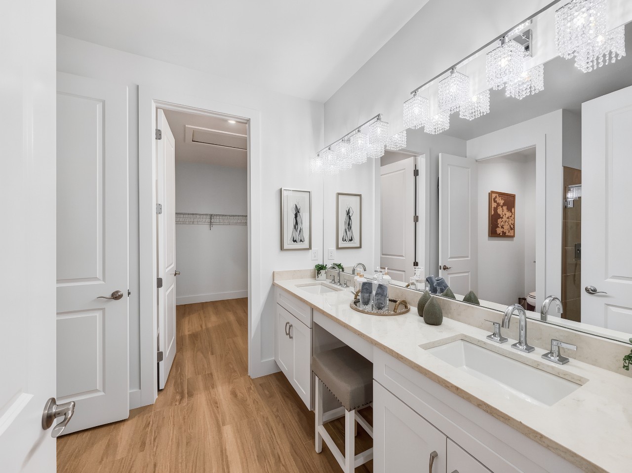 Step into your elegant ensuite retreat, where dual vanities and sparkling chandeliers create a spa-like sanctuary for your daily rituals.