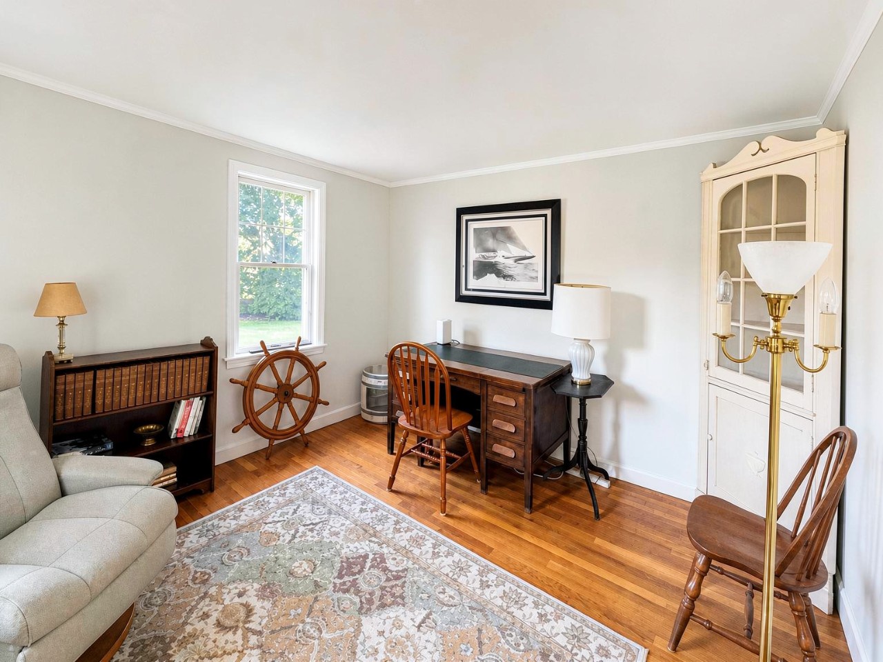 Step into your cozy workspace filled with natural light, where vintage nautical charm meets coastal comfort. Settle in at the desk with warm wooden floors beneath your feet and classic New England touches all around.