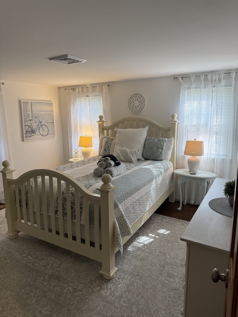 Step into your serene bedroom retreat, where soft natural light filters through plantation shutters and plush bedding invites you to sink in after a day of exploring.