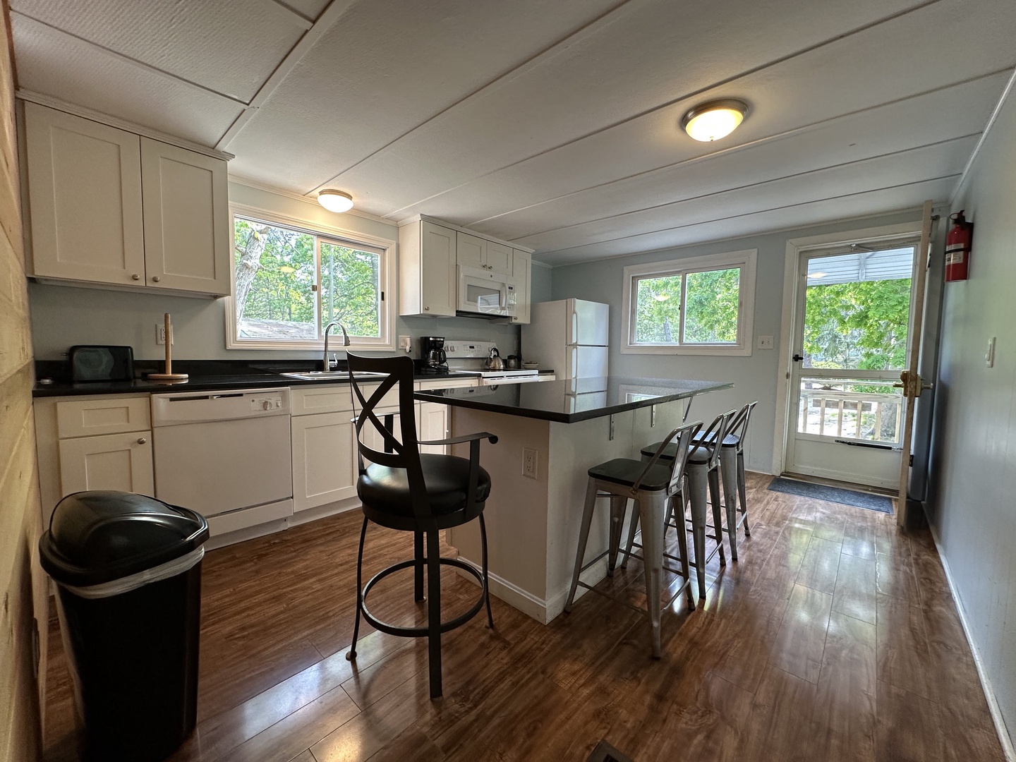 Your fully equipped kitchen features gleaming countertops and breakfast bar seating, perfect for morning coffee or casual meals together.