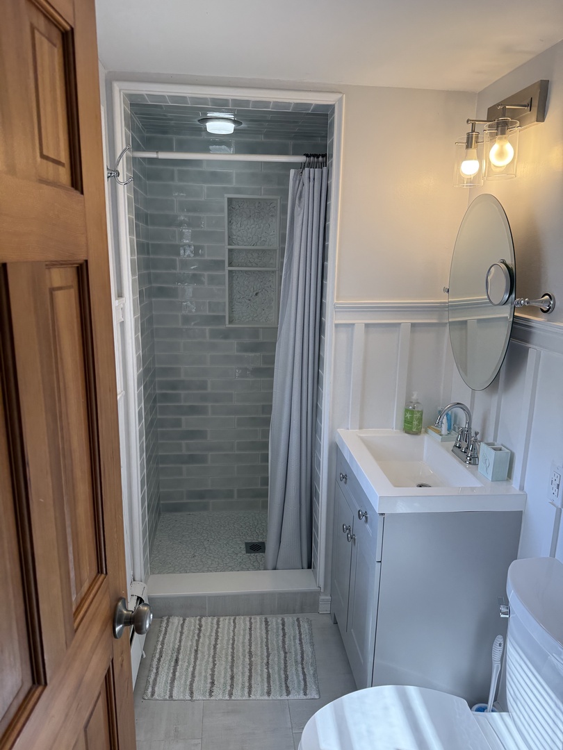 Step into your private spa-like bathroom featuring a spacious glass-enclosed shower, rainfall showerhead, and elegant modern fixtures—your perfect retreat after exploring the area.