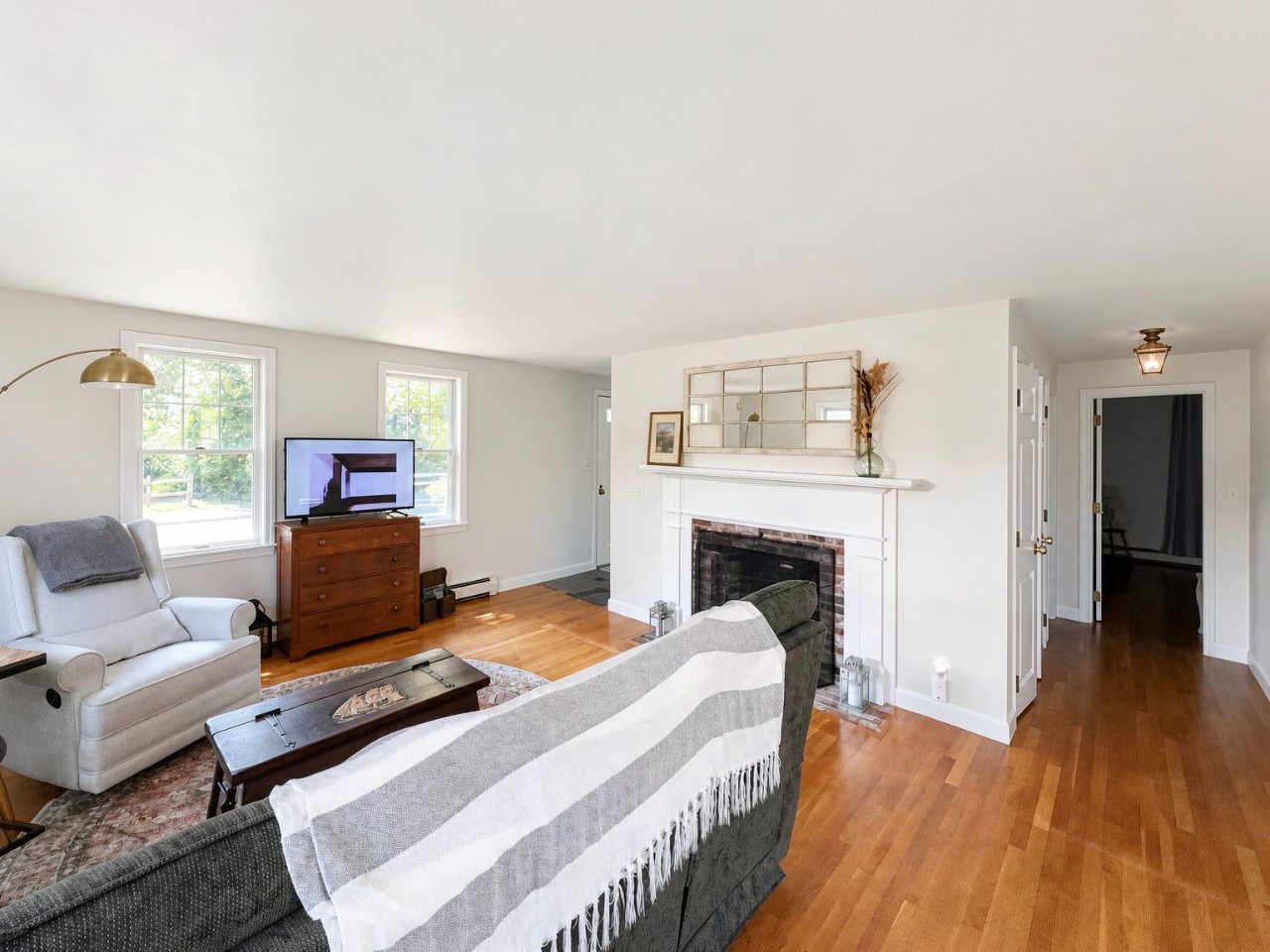 Unwind in your bright living room with cozy seating, warm wood floors, and a charming fireplace—perfect for relaxing after exploring the area.