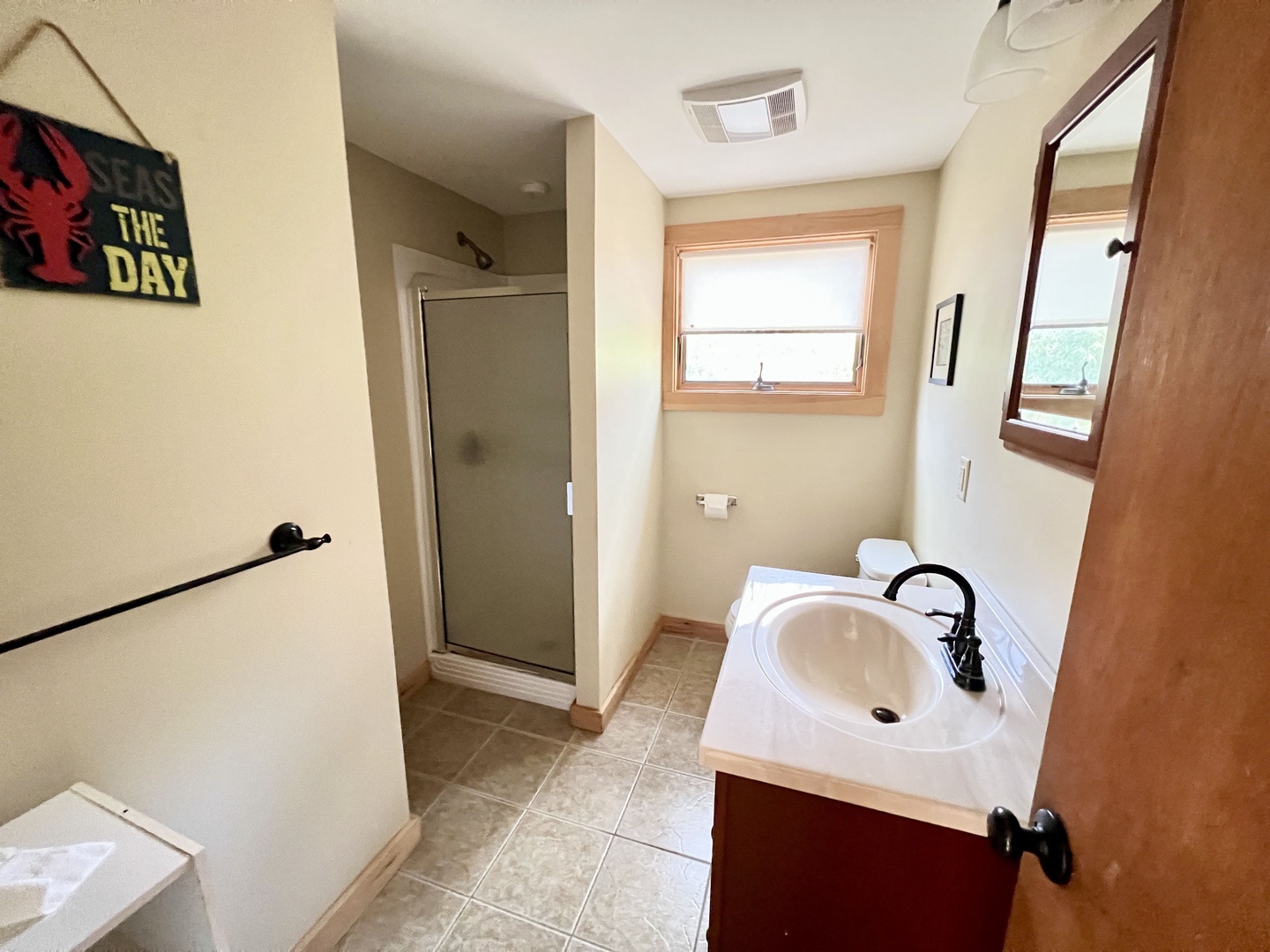 Your private bathroom features a refreshing shower and cozy sink, with natural light streaming through the window to brighten your morning routine.