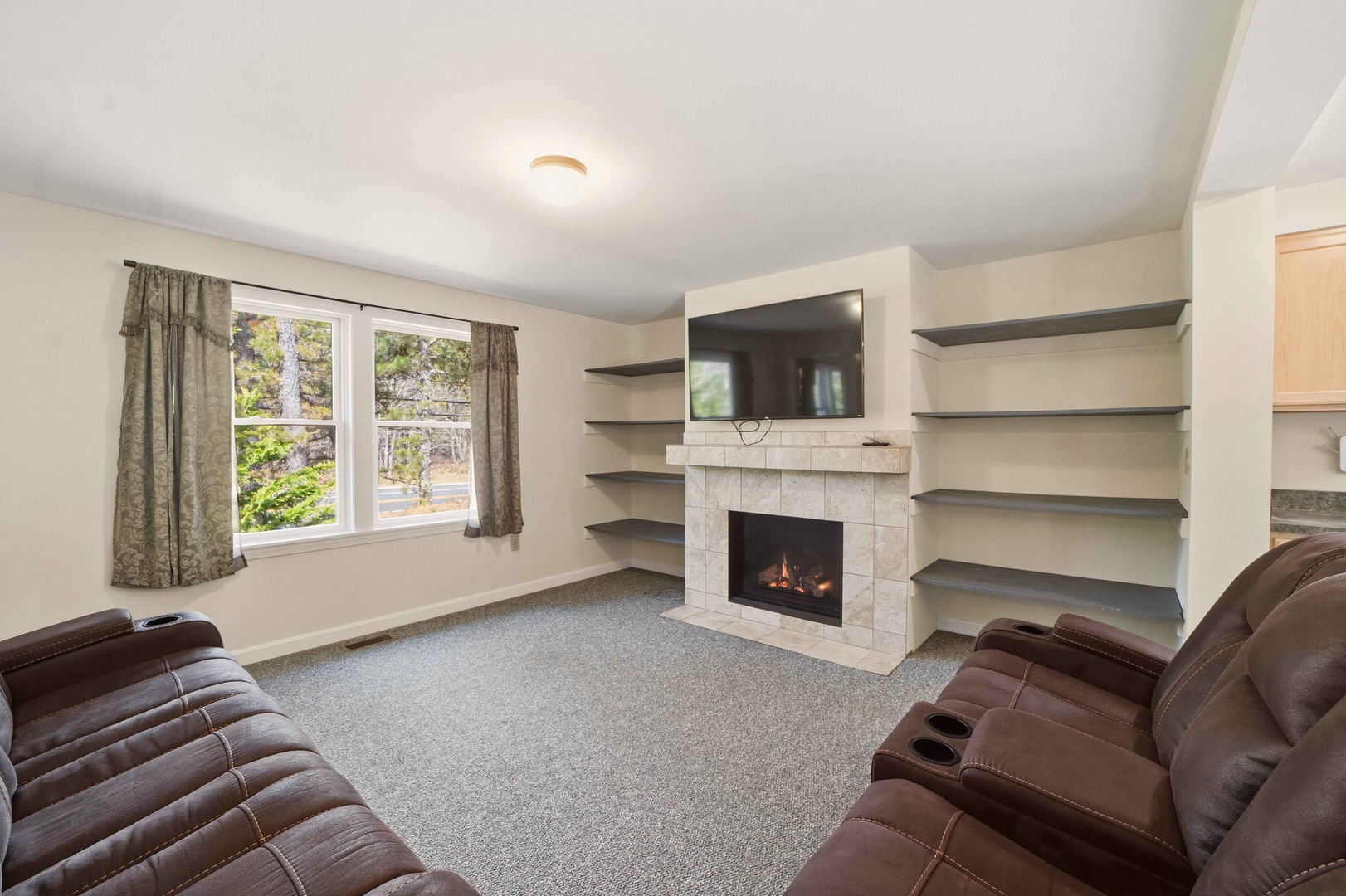Cozy up in your spacious living room with built-in shelving and a warm fireplace, perfect for relaxing after adventures.