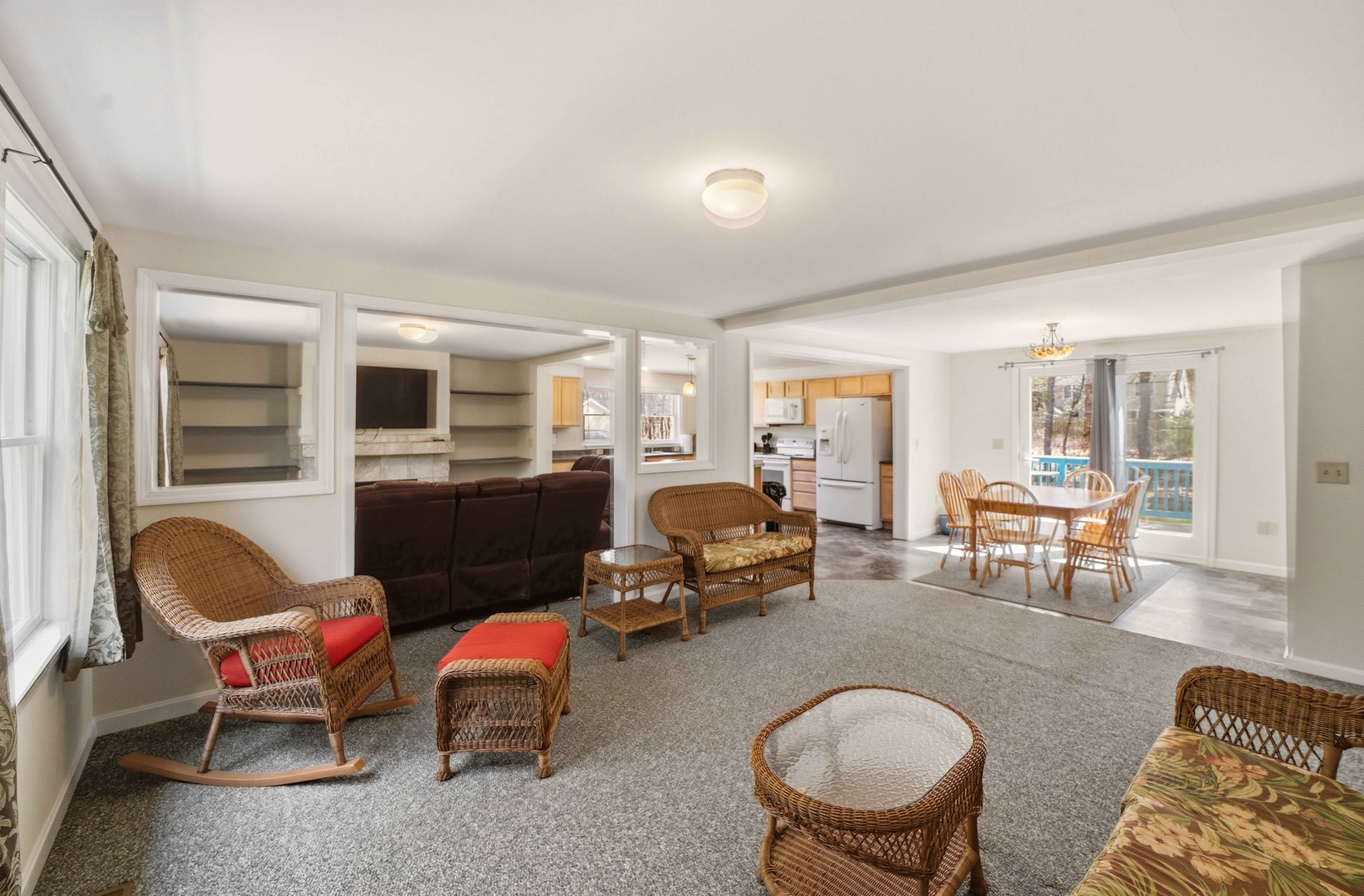 Relax in this charming open-concept living space where wicker furniture creates cozy conversation areas that flow seamlessly into your fully equipped kitchen and dining room.