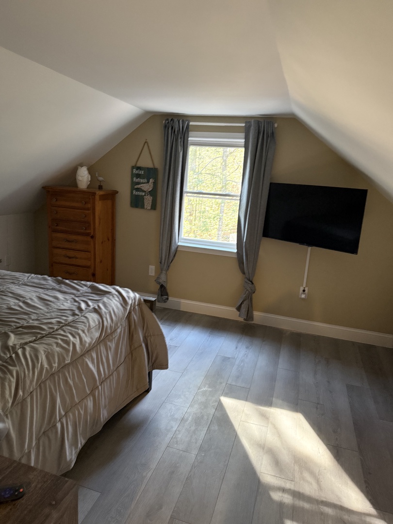 Your cozy bedroom features a comfortable bed with soft linens and natural light streaming through the window.