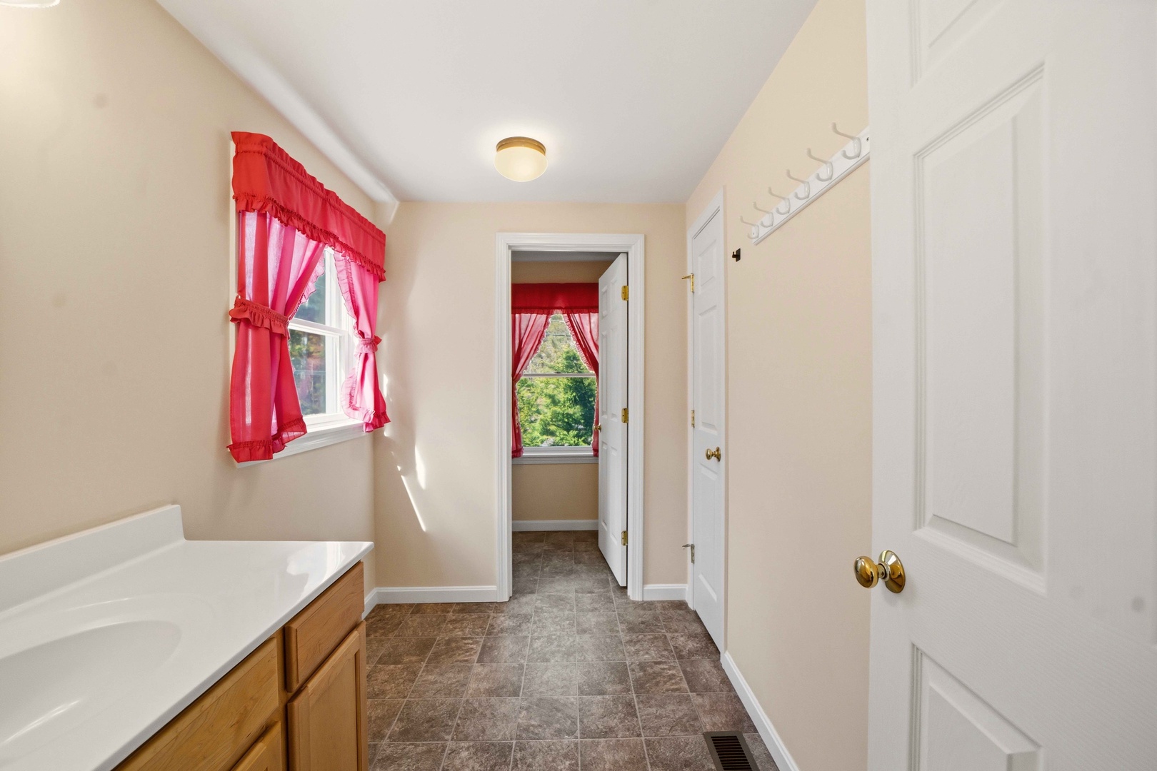Your private laundry space features cheerful red curtains and plenty of natural light for easy care of your vacation wardrobe.