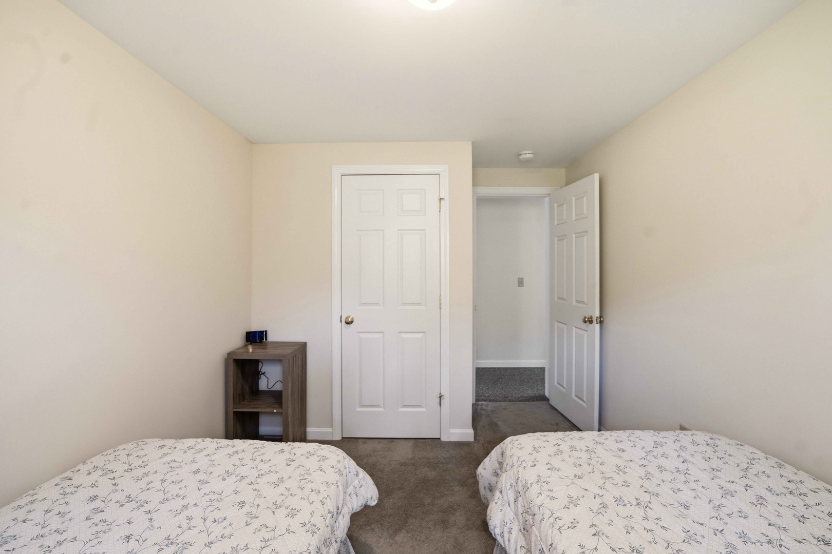 Two comfortable beds await in your peaceful bedroom, with plenty of storage space and easy bathroom access for a restful stay.