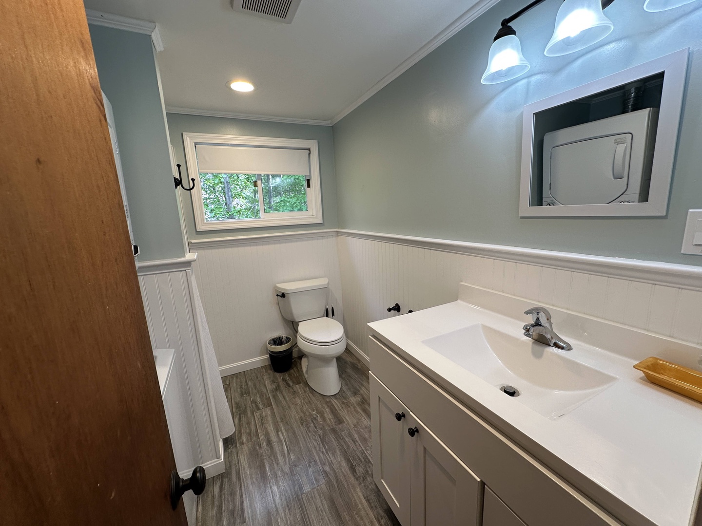 Step into your pristine bathroom with calming coastal colors, modern vanity, and natural light filtering through the window.