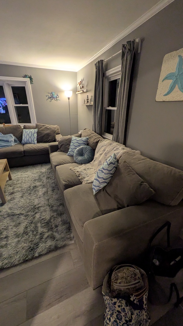 Sink into plush sofas with coastal-inspired pillows in this calming living space where soft lighting creates the perfect ambiance for your evening relaxation.