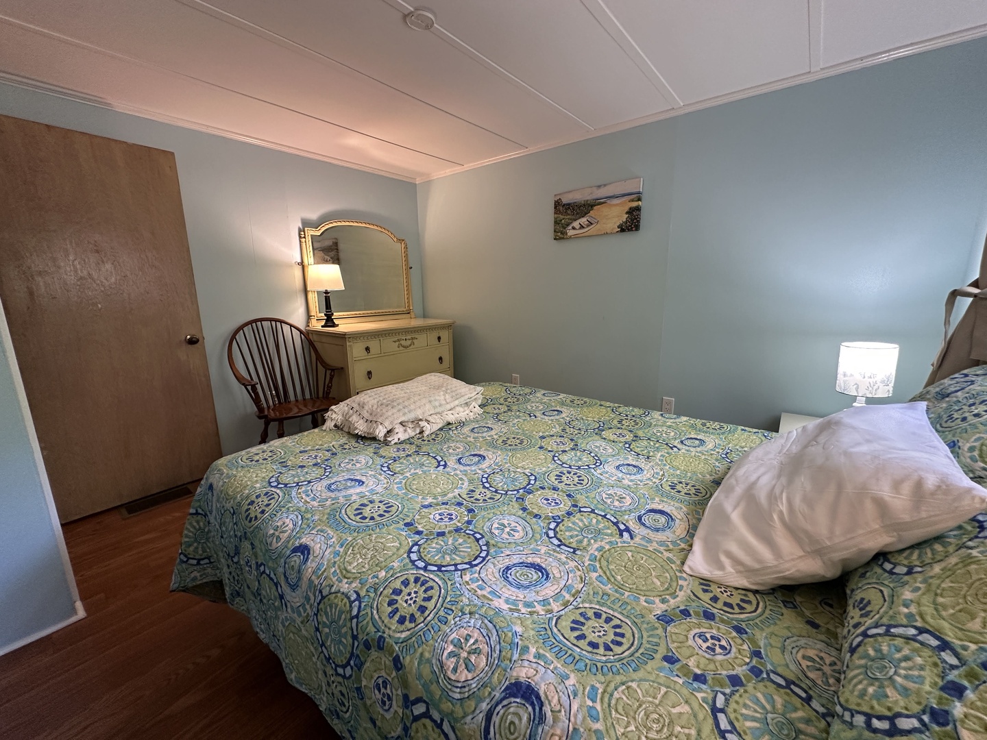 Unwind in your peaceful bedroom featuring a comfortable bed, charming vanity area, and soothing coastal colors that promise restful nights.