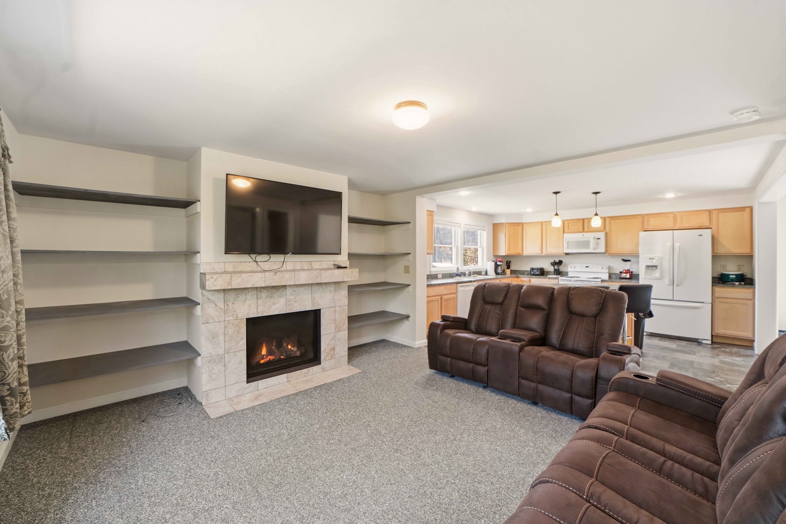 Sink into plush recliners by your cozy fireplace while enjoying the open kitchen layout perfect for entertaining.