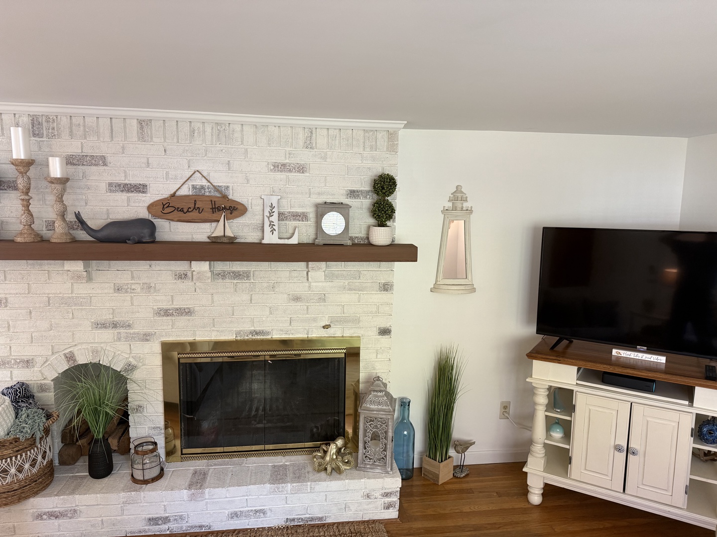 Settle into your living room where a whitewashed brick fireplace creates a warm centerpiece, perfect for cozy evenings in after your beach adventures.