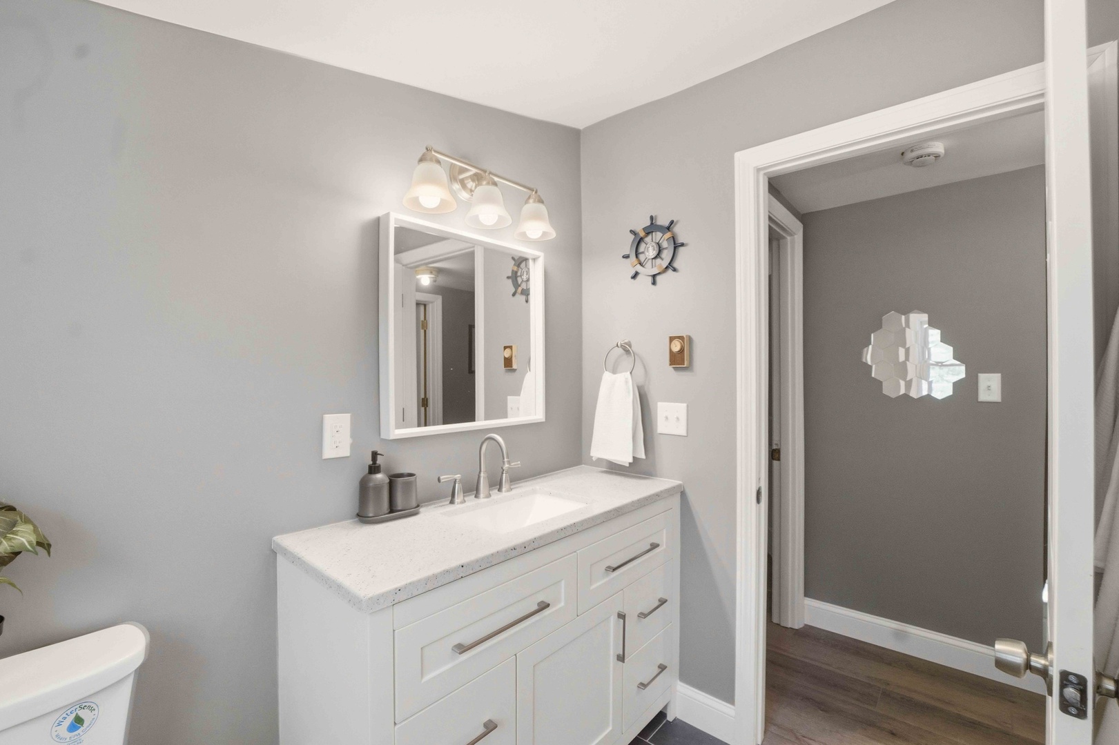 Refresh in your stylish bathroom featuring a spacious vanity, beautiful mirror, and coastal nautical touches that create a calming atmosphere.