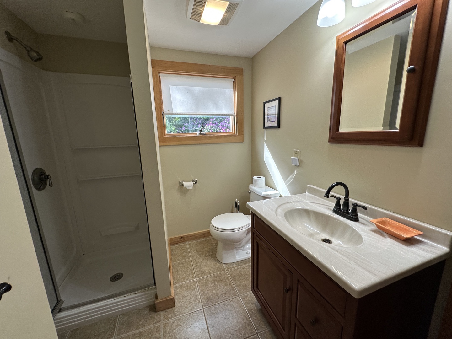 Step into your beautifully appointed bathroom featuring a glass shower, elegant vanity with marble countertop, and warm wood accents that create a spa-like retreat.