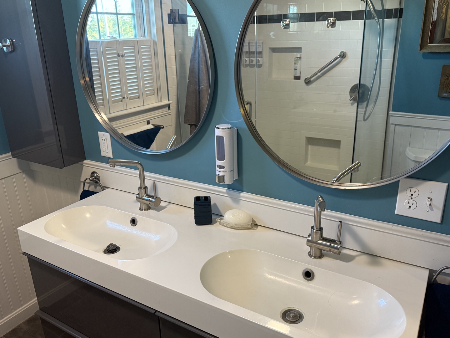 Your stylish double vanity makes mornings a breeze with dual sinks, round mirrors, and sleek modern fixtures.