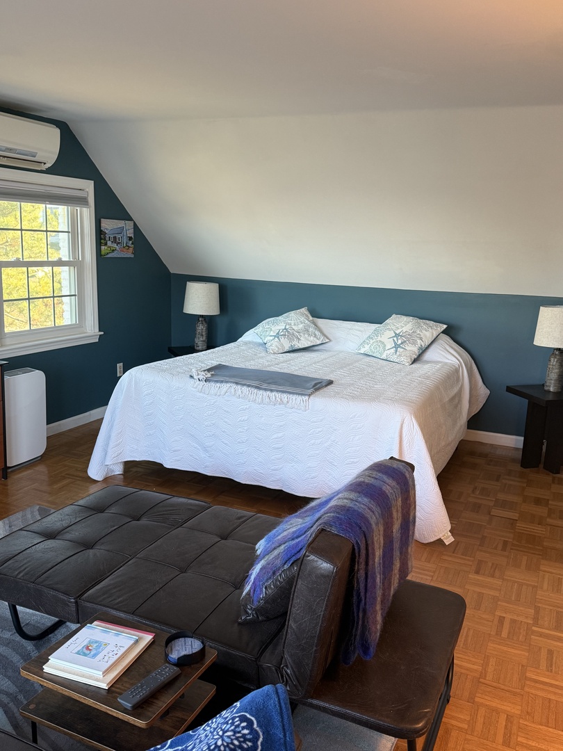 Sink into crisp white linens and let the warm wood floors ground your peaceful retreat in this cozy bedroom.