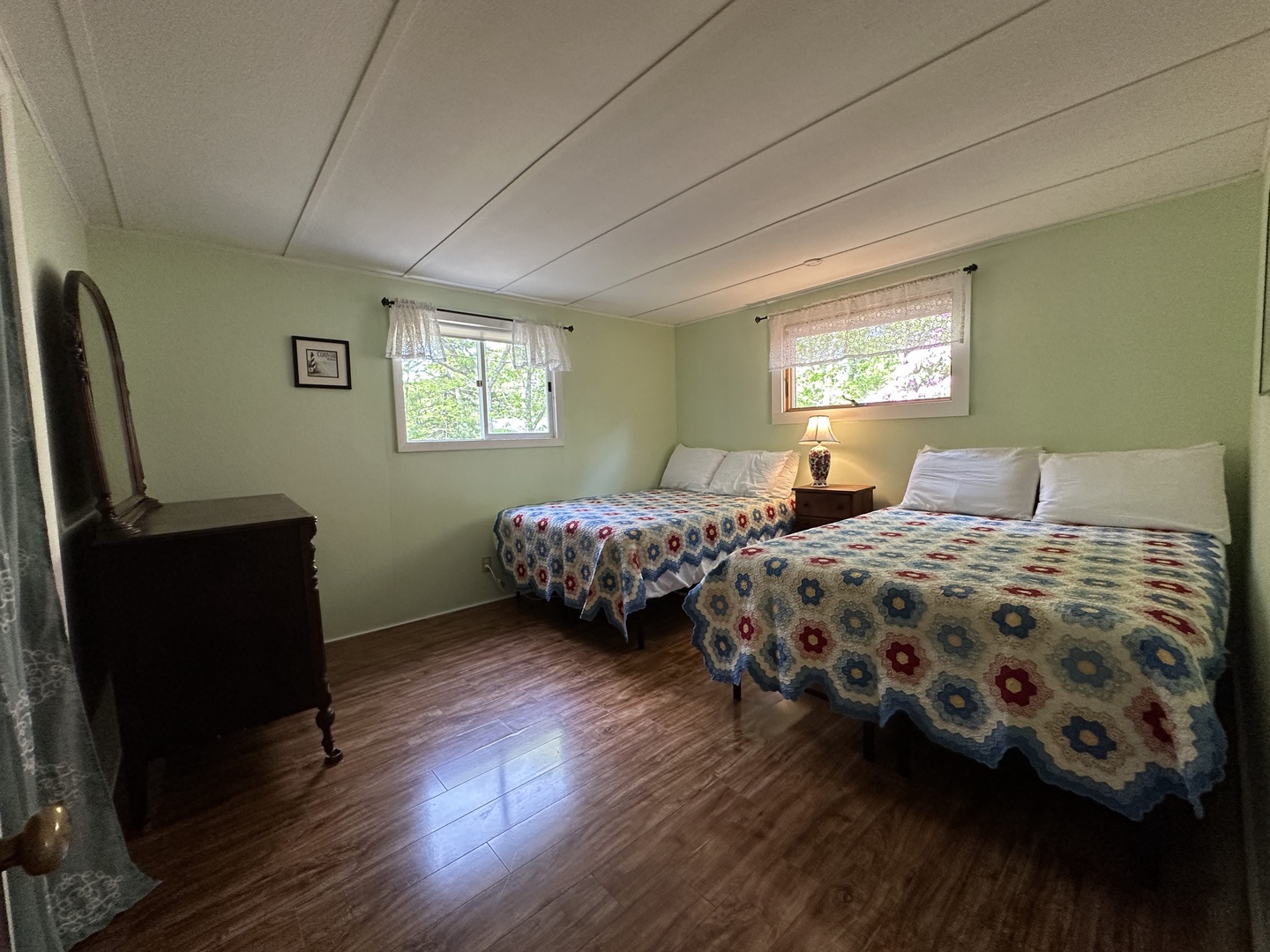 Sink into comfort with matching quilted beds and vintage charm in your cozy retreat.