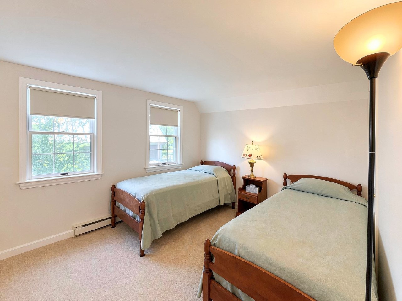 Two comfortable twin beds await you in this bright, peaceful room, with natural light from large windows and gentle ambient lighting for a restful night.