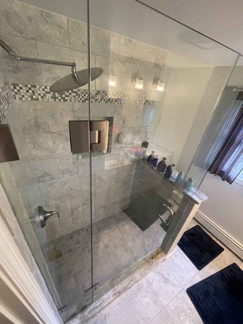 Step into your luxurious bathroom oasis with sleek glass shower, modern fixtures, and elegant stone tilework creating a spa-like retreat.