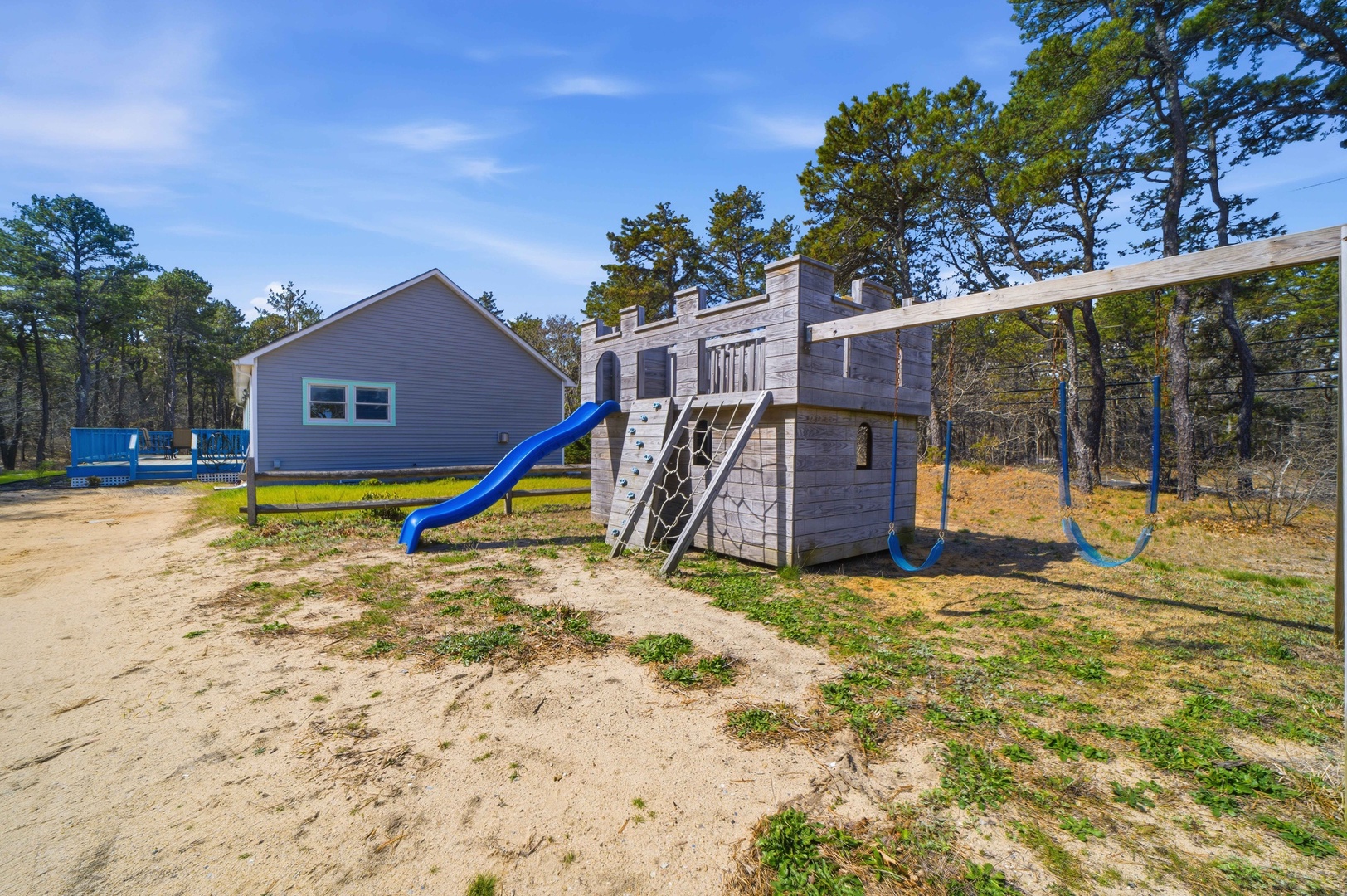 Adventure awaits at this castle-themed playground with slides and swings, surrounded by peaceful wooded grounds.