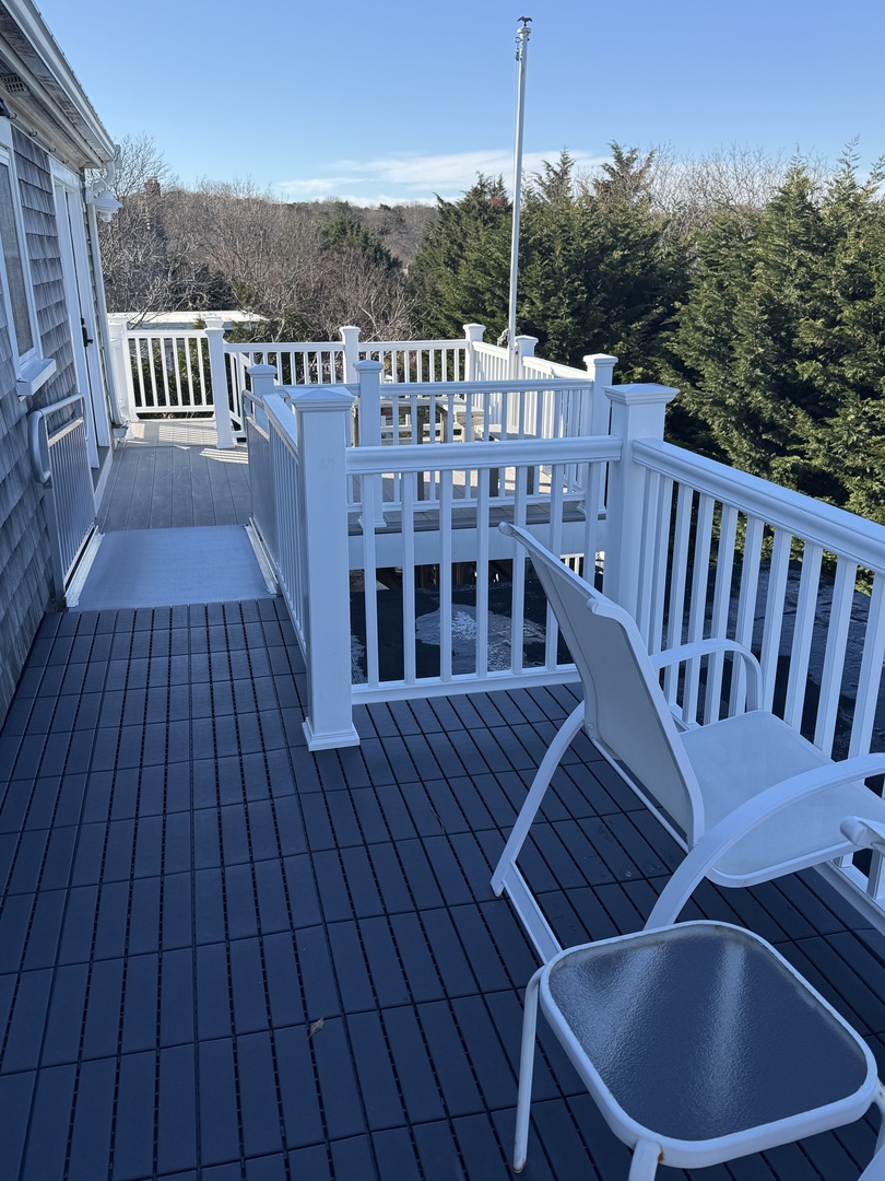 Your private balcony features elegant white seating where you can unwind with morning coffee or evening relaxation, overlooking peaceful surroundings.