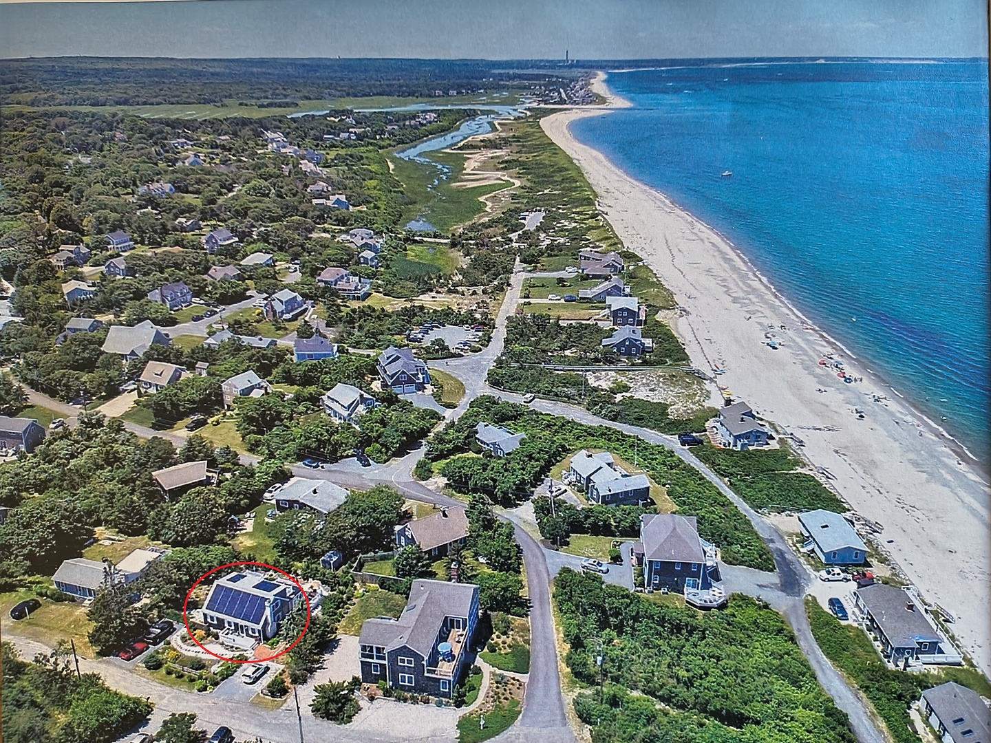 Aerial view of coastal neighborhood with pristine sandy beaches and turquoise waters stretching along the shoreline.
