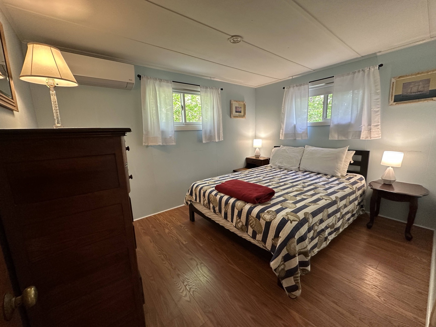 Unwind in your peaceful bedroom with soft bedding, warm lamp lighting, and charming vintage touches.