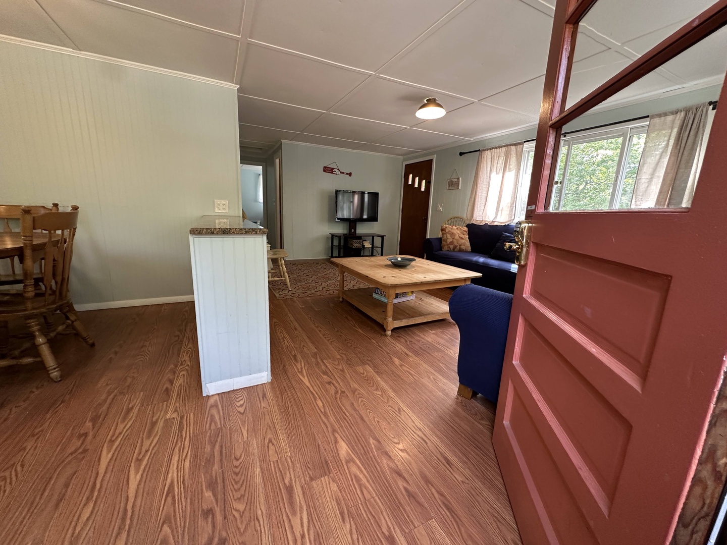 Unwind in your spacious living room with plush blue seating and warm wood floors that invite barefoot mornings.