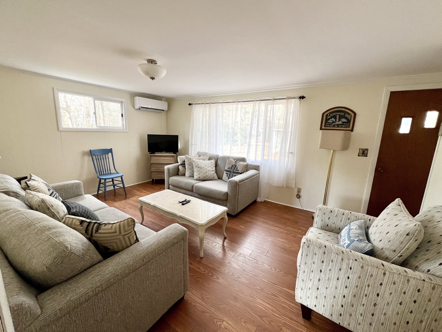 Sink into plush seating in your bright living room, where natural light streams through sheer curtains and hardwood floors invite barefoot mornings.