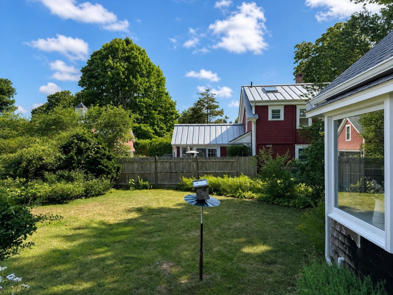 Expansive backyard with lush green lawn and mature trees, offering plenty of space for outdoor relaxation and activities during your stay.