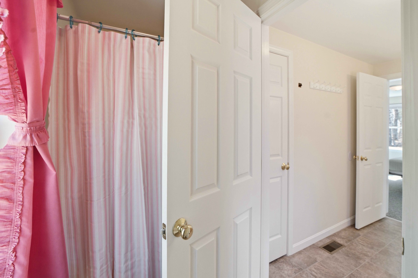 Your private bathroom features a charming pink shower curtain and spacious closets for storing all your belongings.
